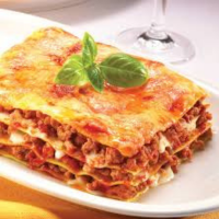 Bu tarif klasik lazanya değildir.
Uzun pişmiş gerçek bir bolognese, dengeli bir beşamel ve fırından çıktıktan sonra tavada hafif kızartılarak elde edilen çıtır doku üzerine kuruludur.

Bolonez sos aceleye gelmez. 2,5 saatten kısa sürede derinlik oluşmaz.